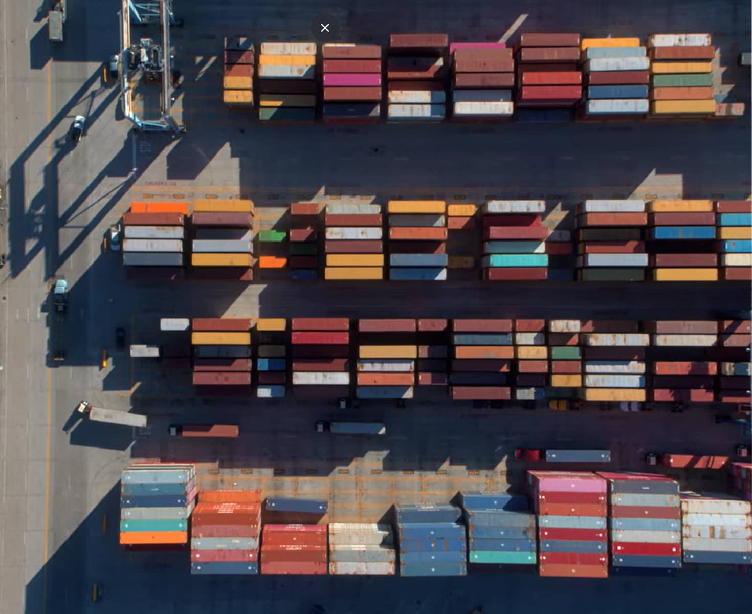Aerial view of a shipping port with rows of colorful cargo containers neatly organized