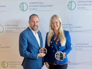 Two people holding awards at the International Economic Development Council.