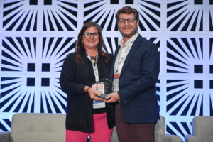 Two people holding an award.