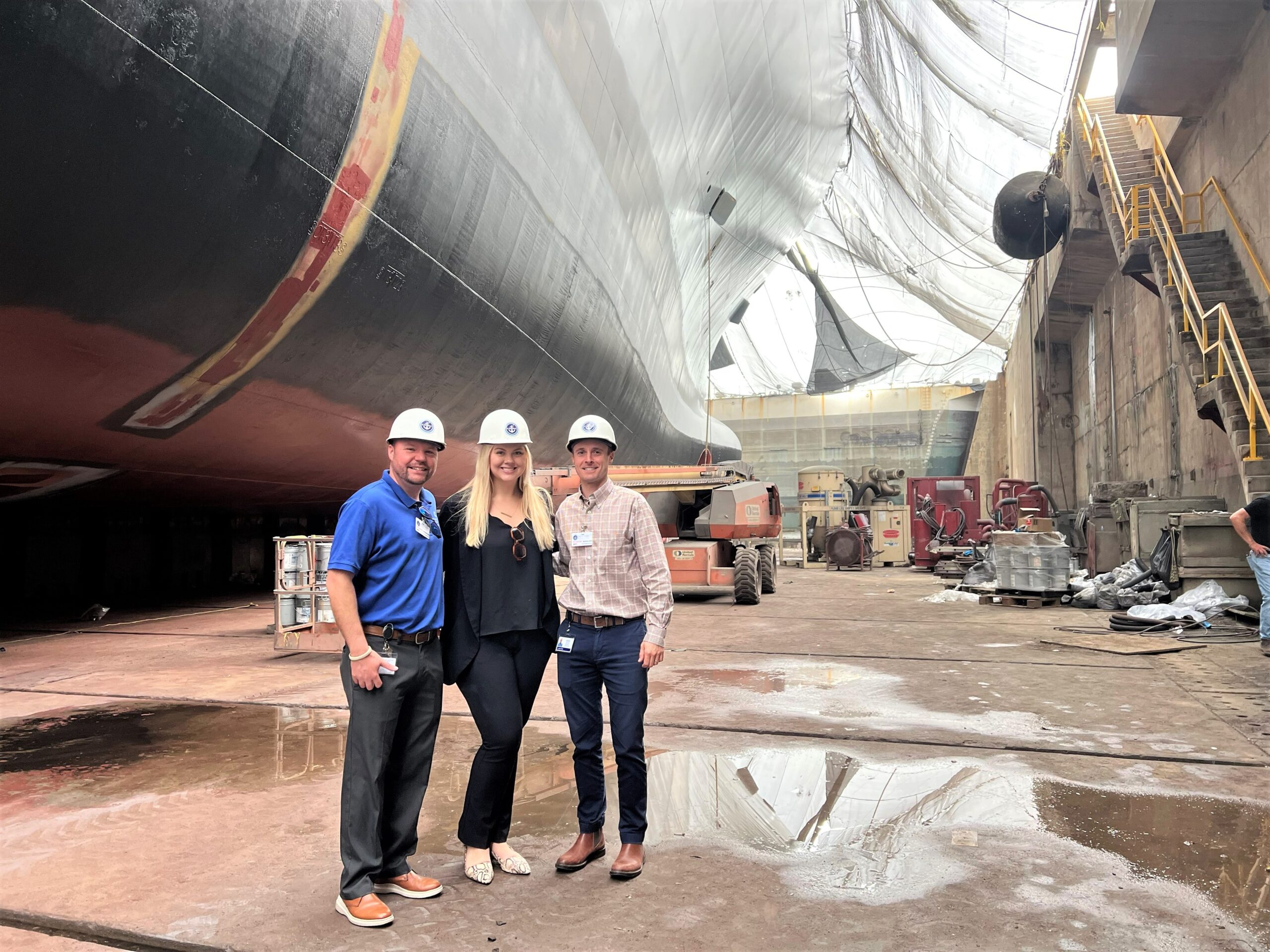 Economic development professionals wearing hard hats during an industrial site visit.